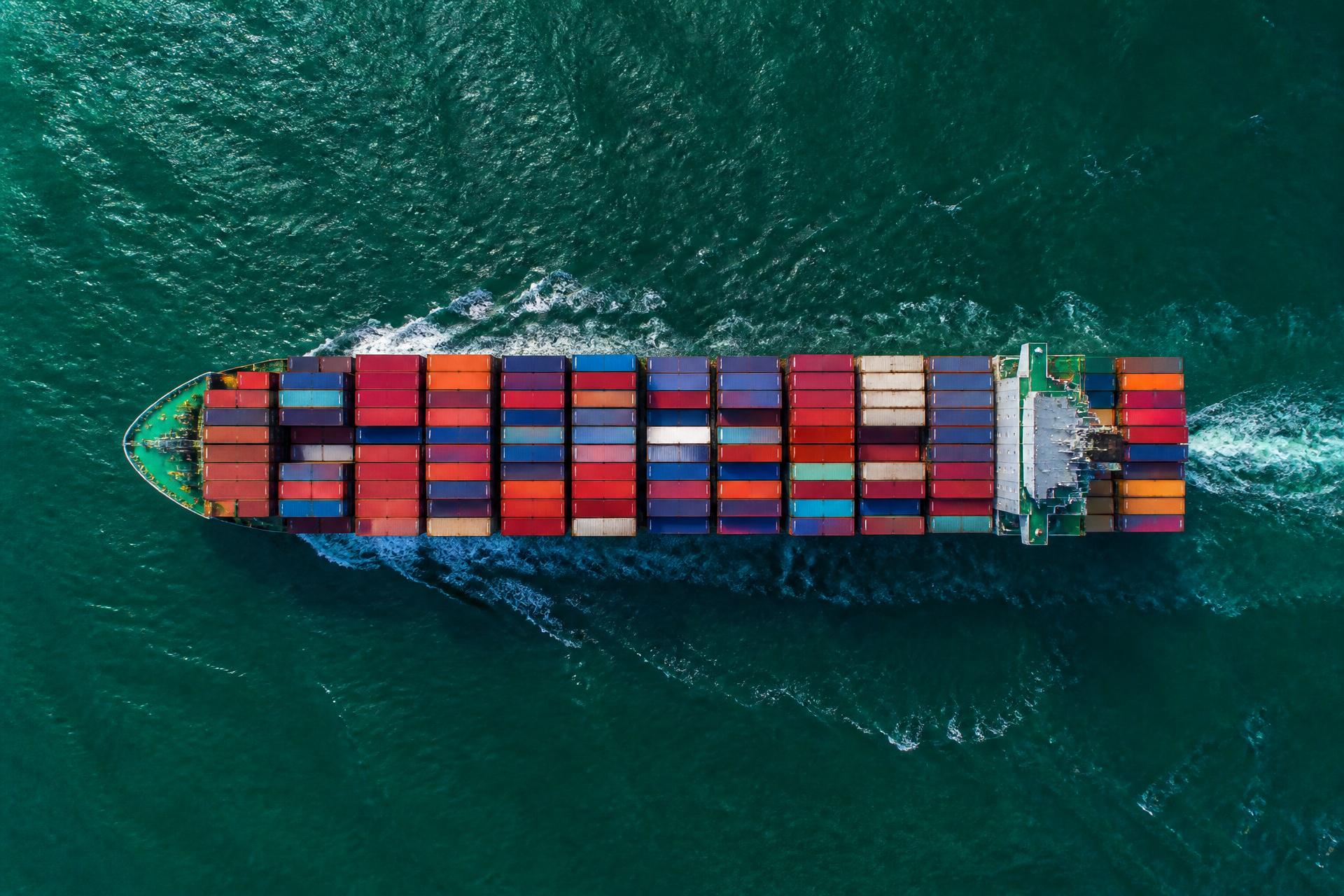 Aerial view of a container ship loaded with shipping containers crossing open water